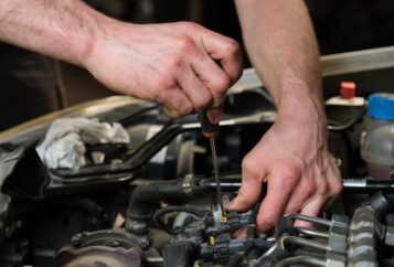 ASE-certified mechanic removing fuel injectors.