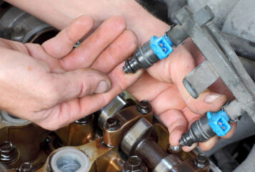 A mechanic working on a fuel injector.