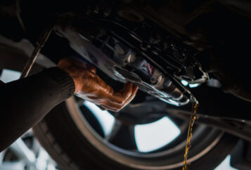 ASE-certified mechanic draining transmission fluid.